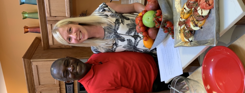 A man and woman standing in front of food.